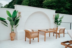 a patio with a table and chairs and a potted plant
