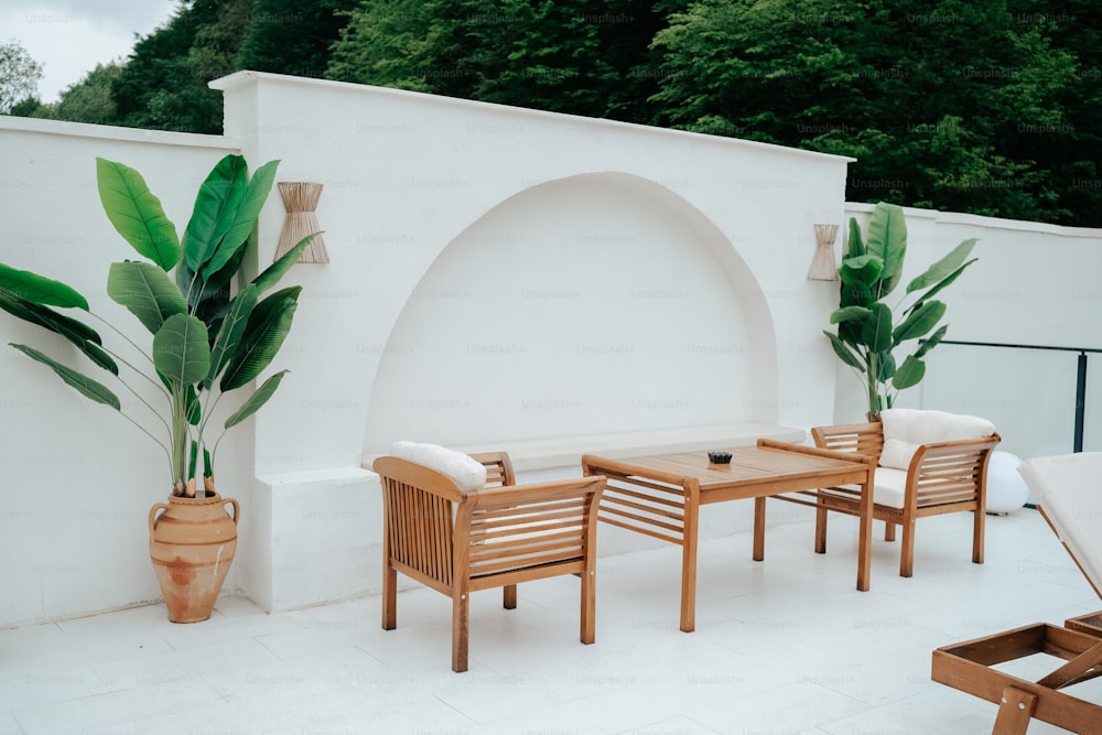 un patio con tavolo e sedie e una pianta in vaso
