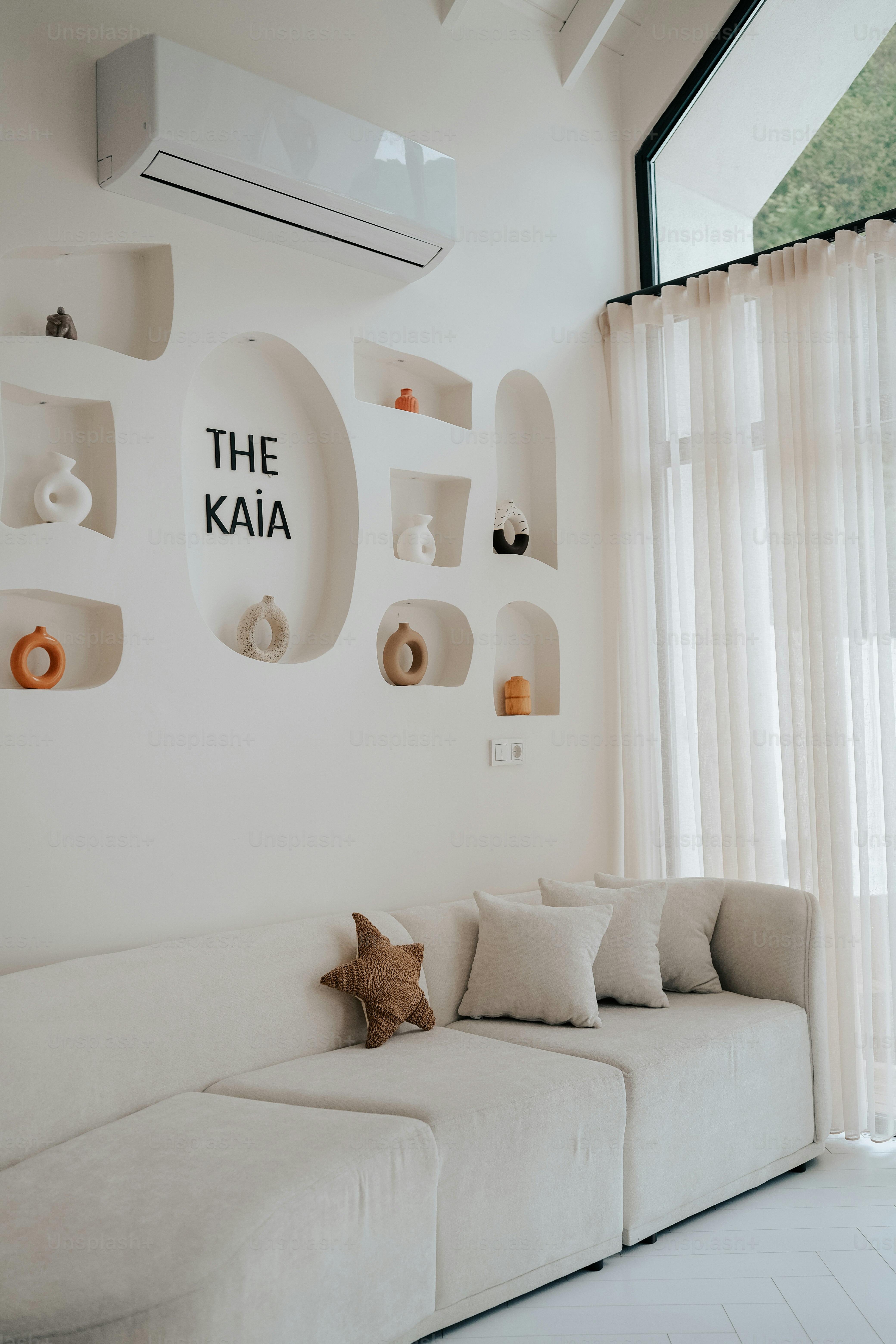 ein Wohnzimmer mit einer weißen Couch und einer weißen Wand