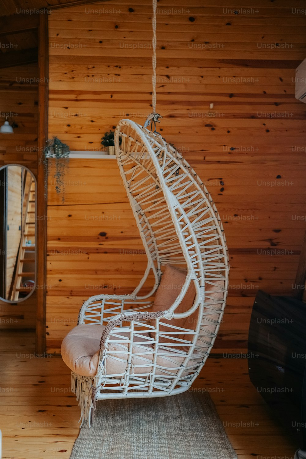 a white hanging chair in a wooden room