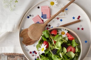 a plate with a salad and a wooden spoon