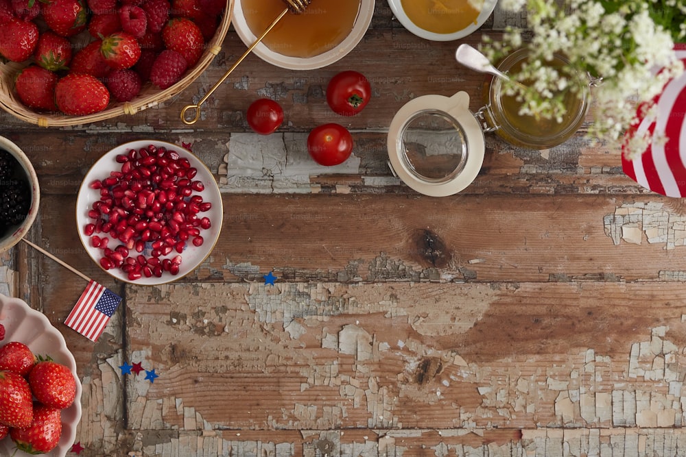 uma mesa de madeira coberta com tigelas de frutas e uma xícara de chá
