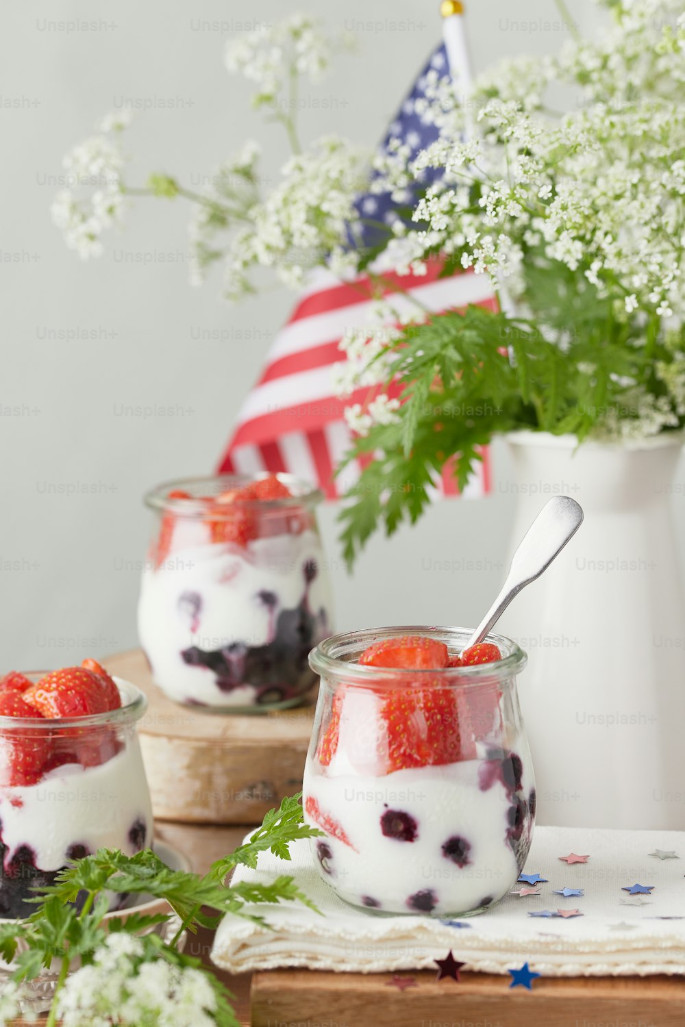 two jars of yogurt with strawberries and berries in them