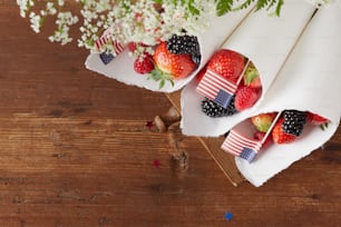 strawberries, strawberries, and blackberries are wrapped in white paper