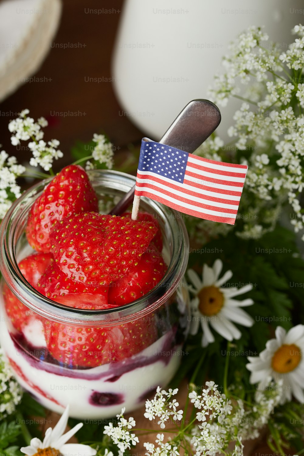strawberries in a jar with a flag sticking out of it