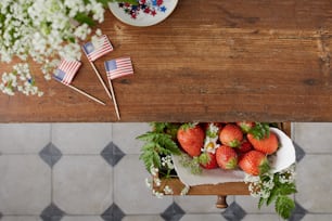 Morangos em uma tigela em uma mesa com bandeiras americanas
