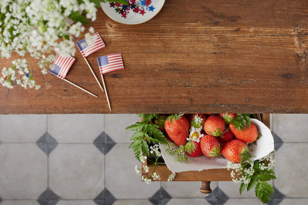 미국 국기가 있는 테이블 위에 그릇에 담긴 딸기