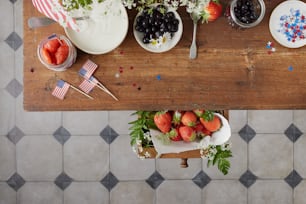 une table en bois surmontée d’assiettes et de bols de fruits