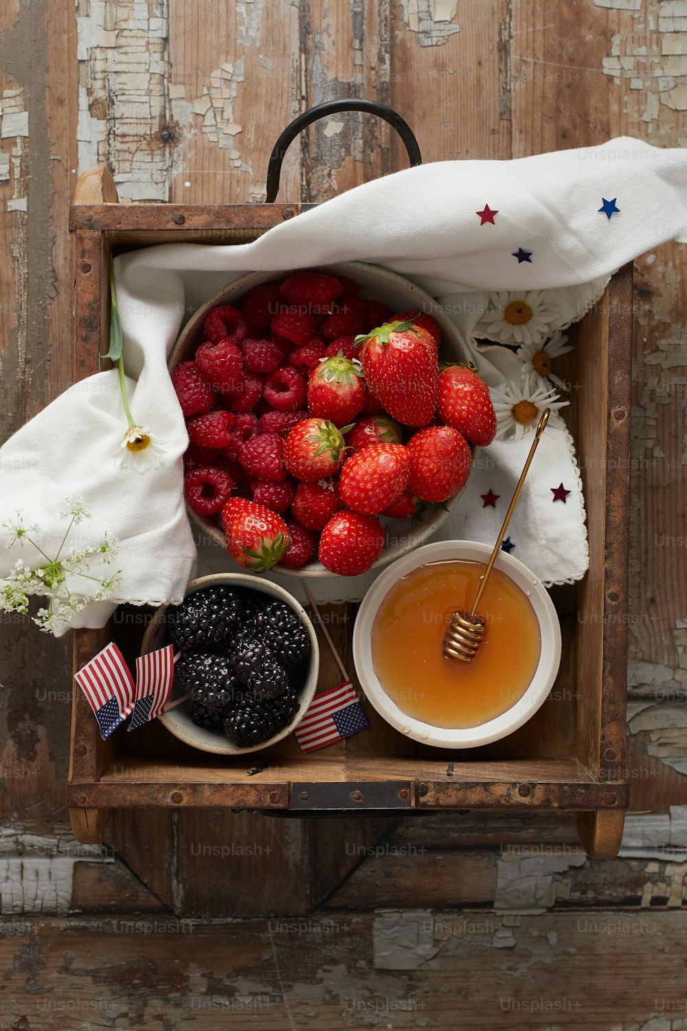 a bowl of strawberries, berries, and a cup of tea