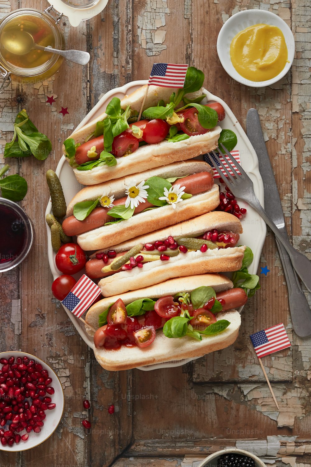 un plato de perros calientes con tomates, tomates y lechuga