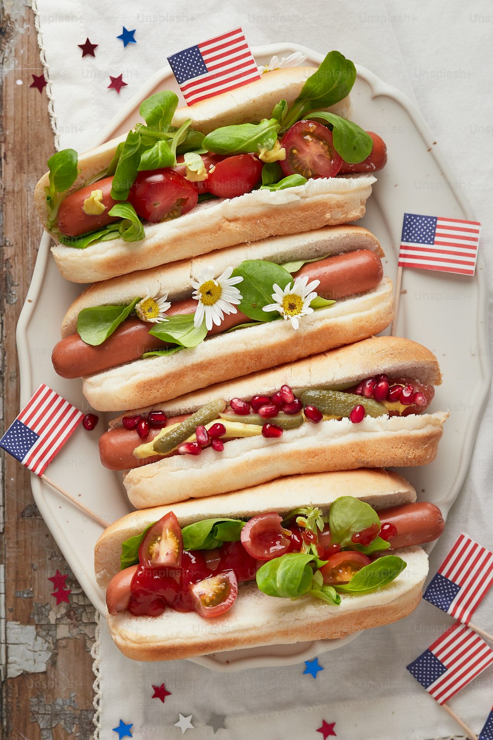 a white plate topped with hot dogs covered in toppings