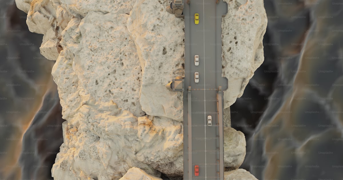 An aerial view of a road between two large rocks photo – Bridge Image ...