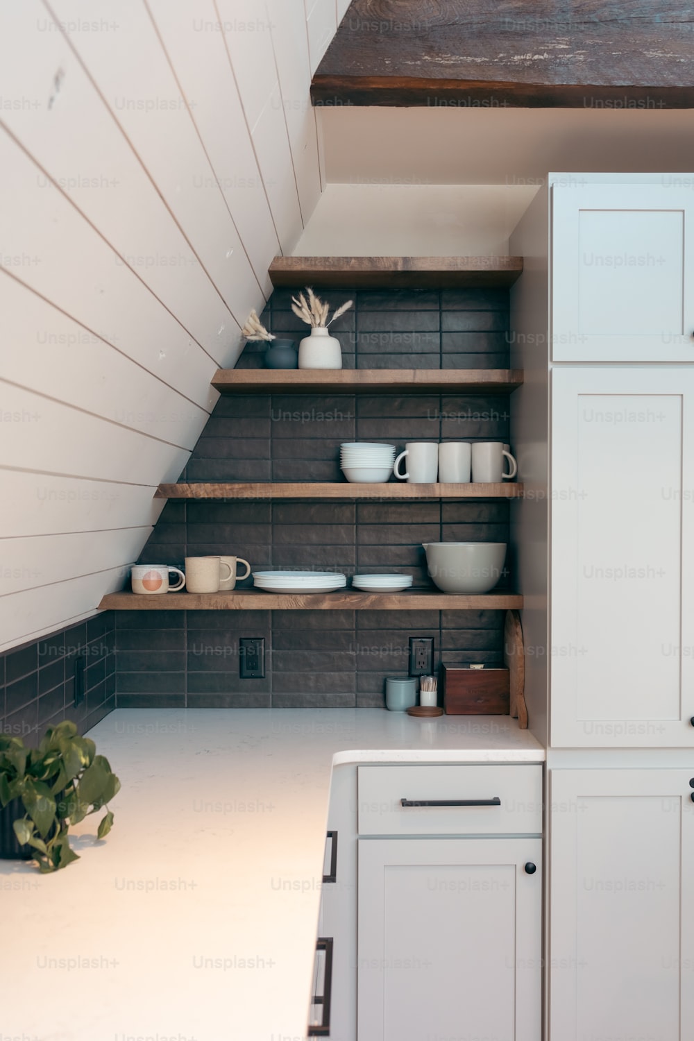 a kitchen with white cabinets and wooden shelves