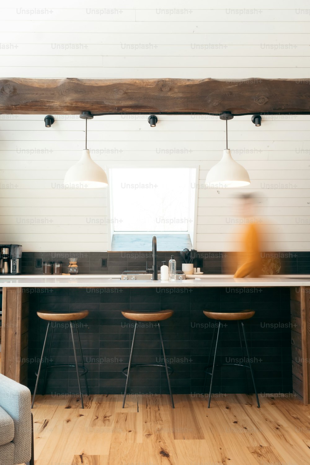 a kitchen with three stools next to a counter