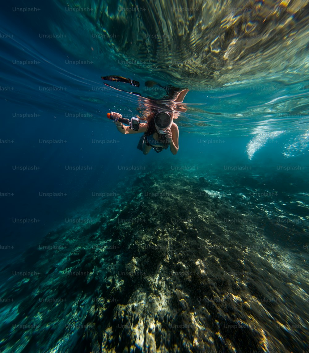 Una persona che nuota nell'oceano con una macchina fotografica