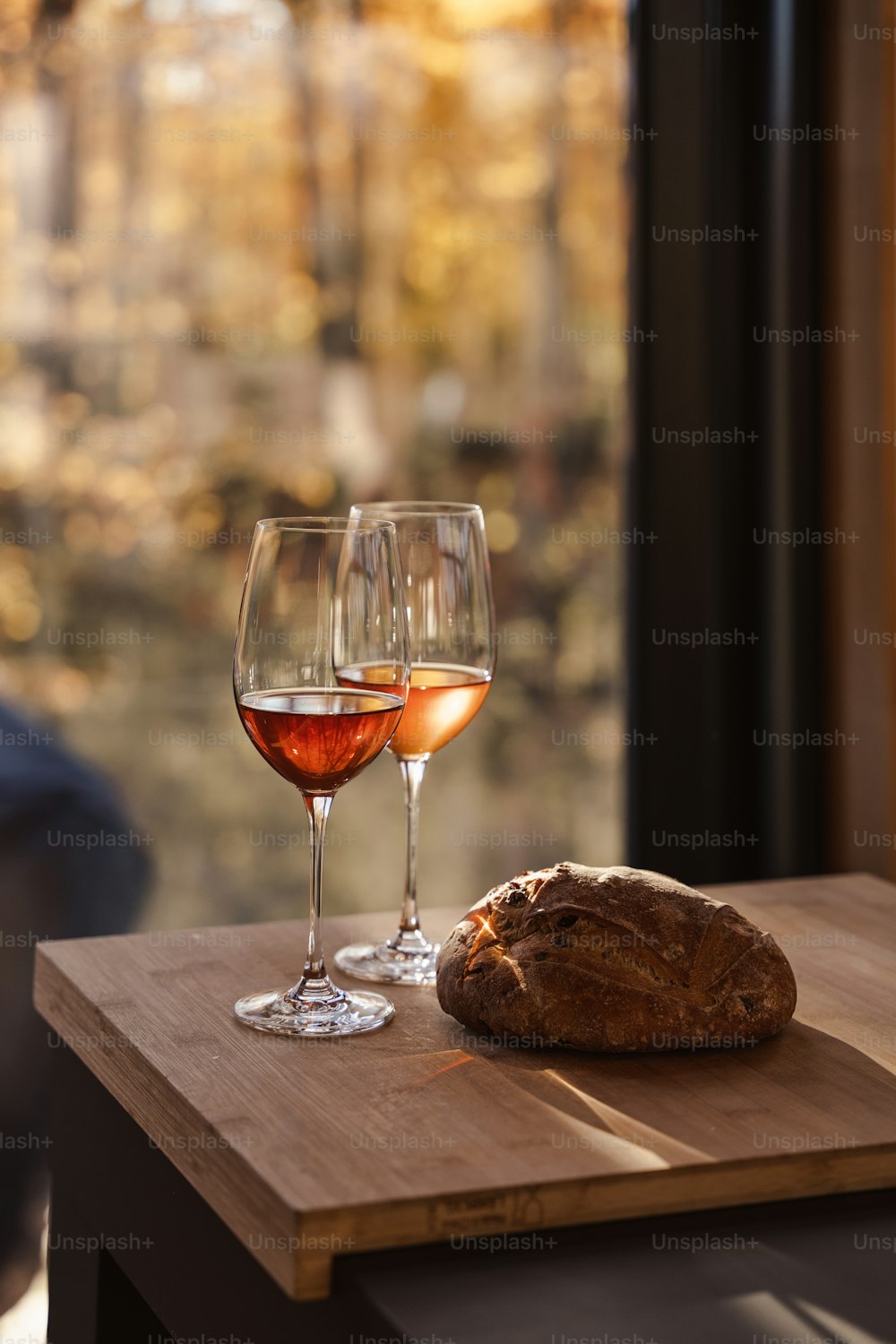 테이블 위에 와인 두 잔과 빵 한 덩어리