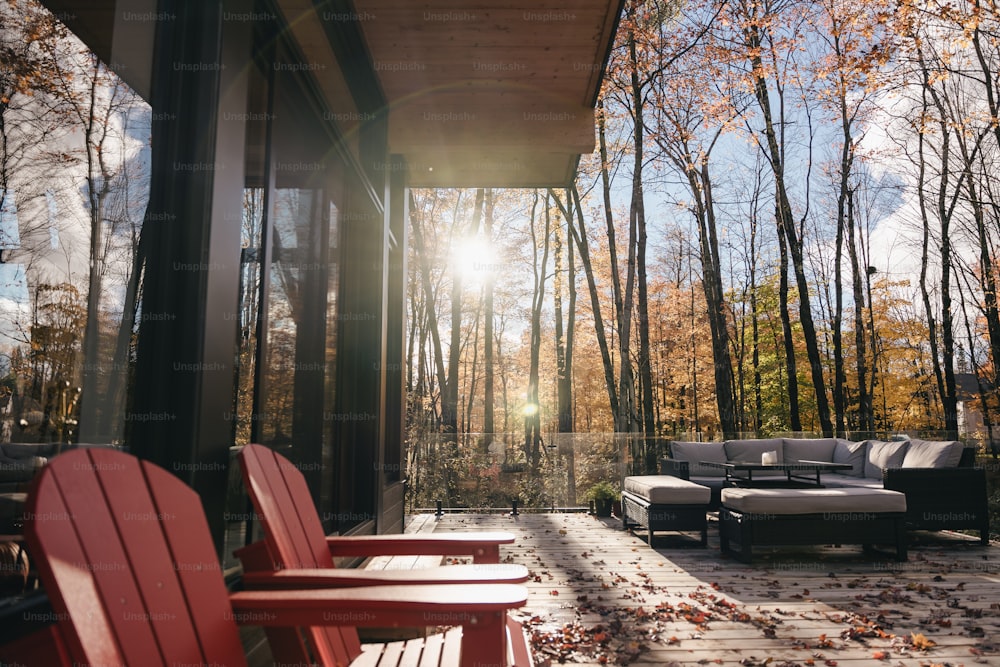 a patio with two red chairs and a couch