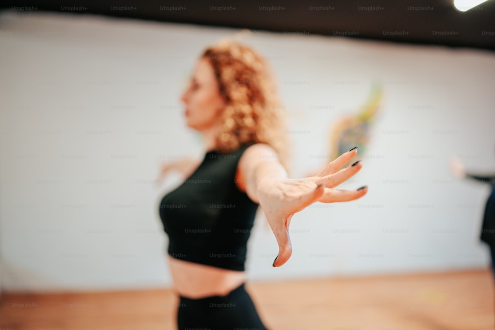 a woman in a black top is doing a yoga pose