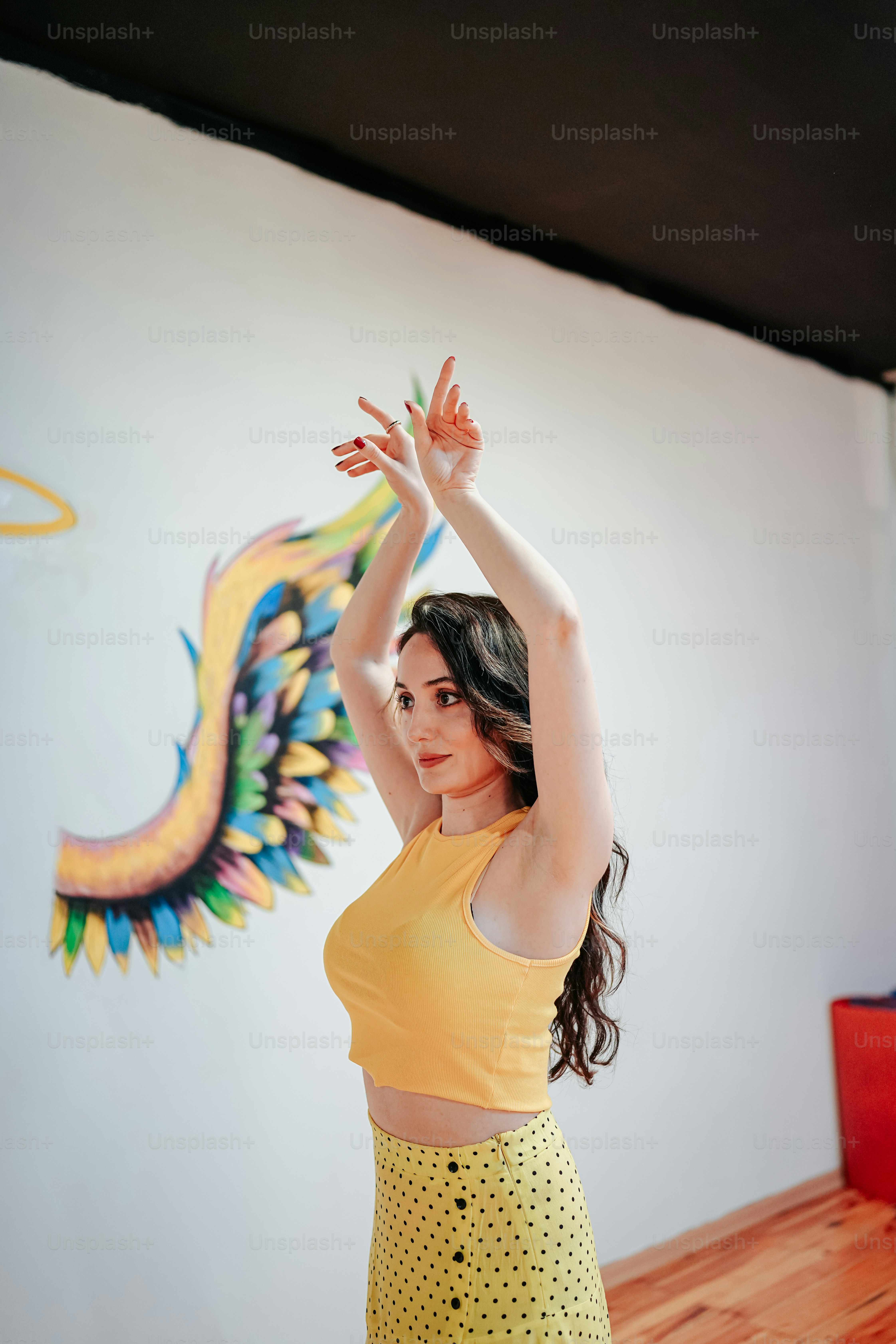 Una mujer con un top amarillo está bailando