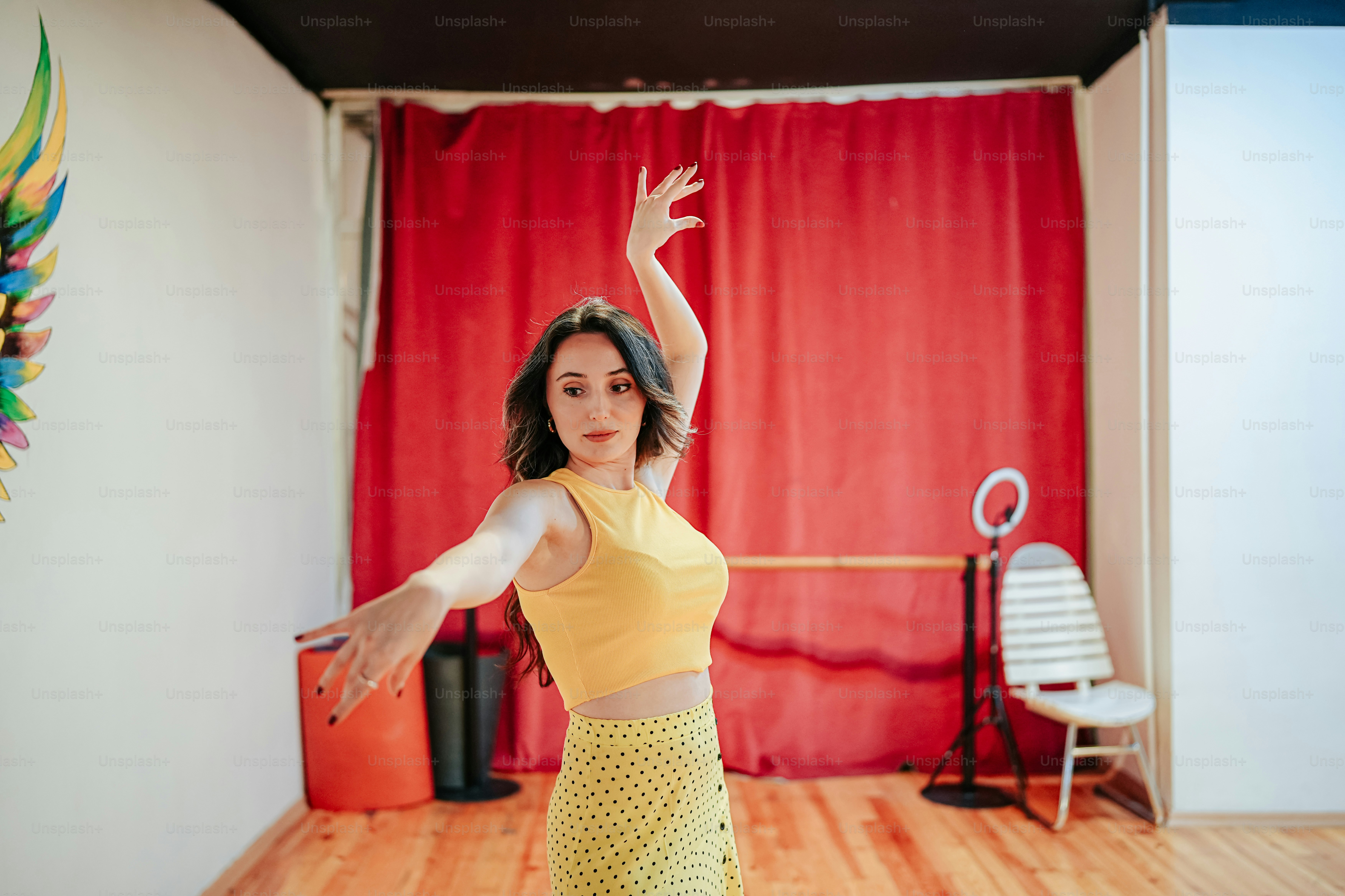 Una mujer con un top amarillo está bailando