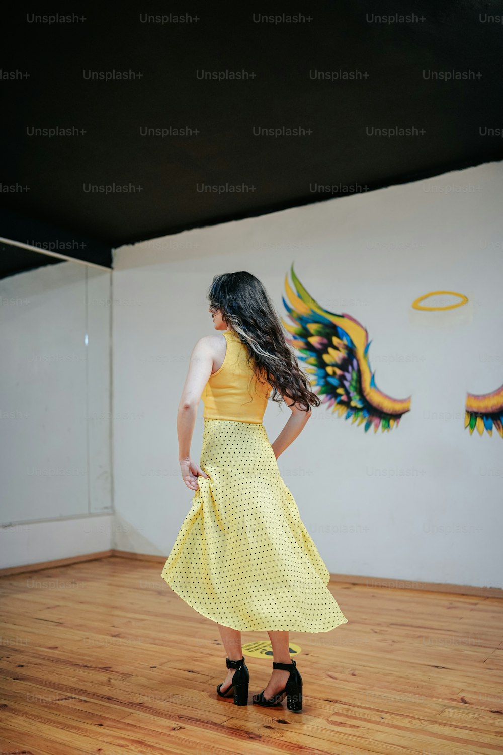 a woman in a yellow dress standing in a room