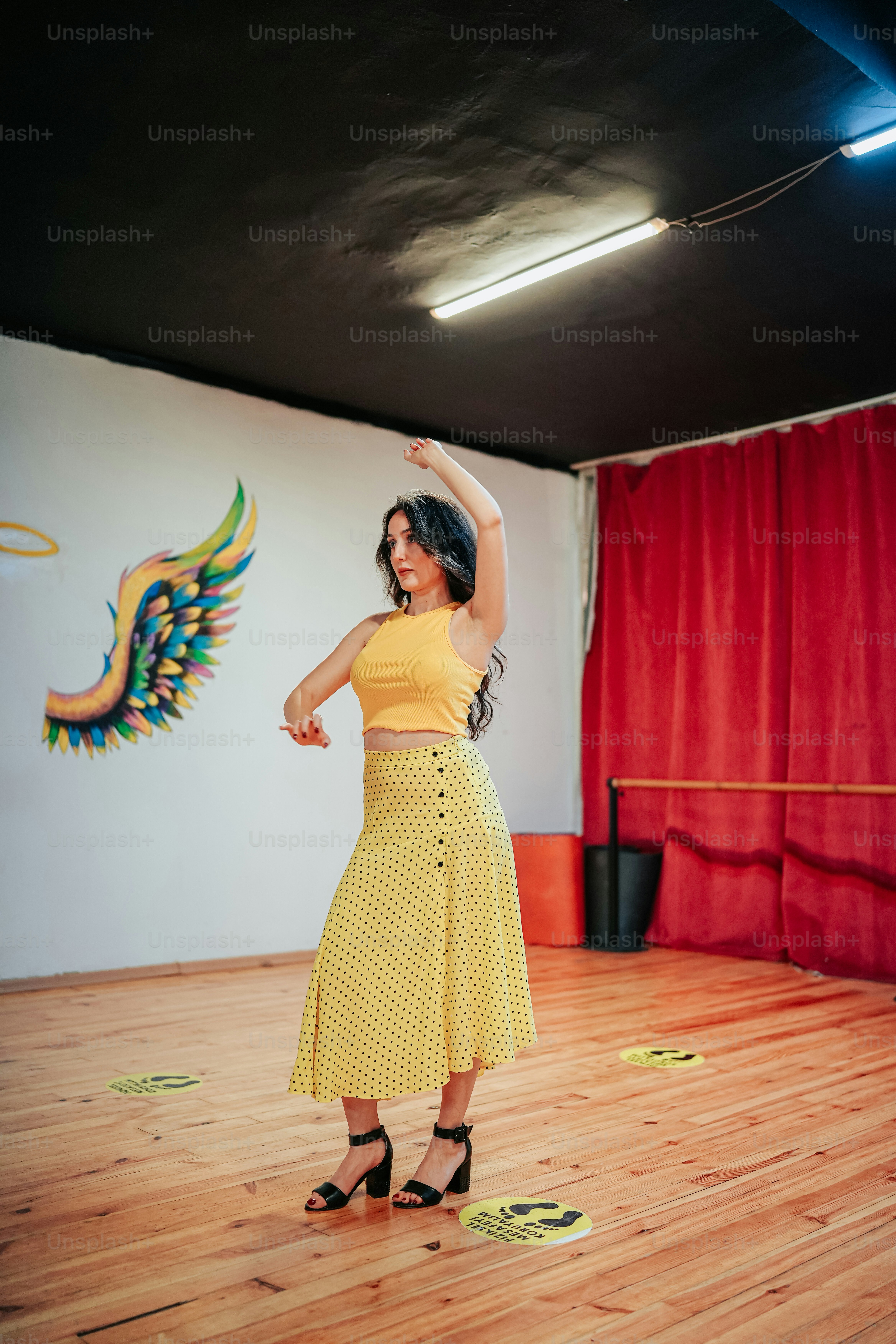 Una mujer con un top amarillo está bailando