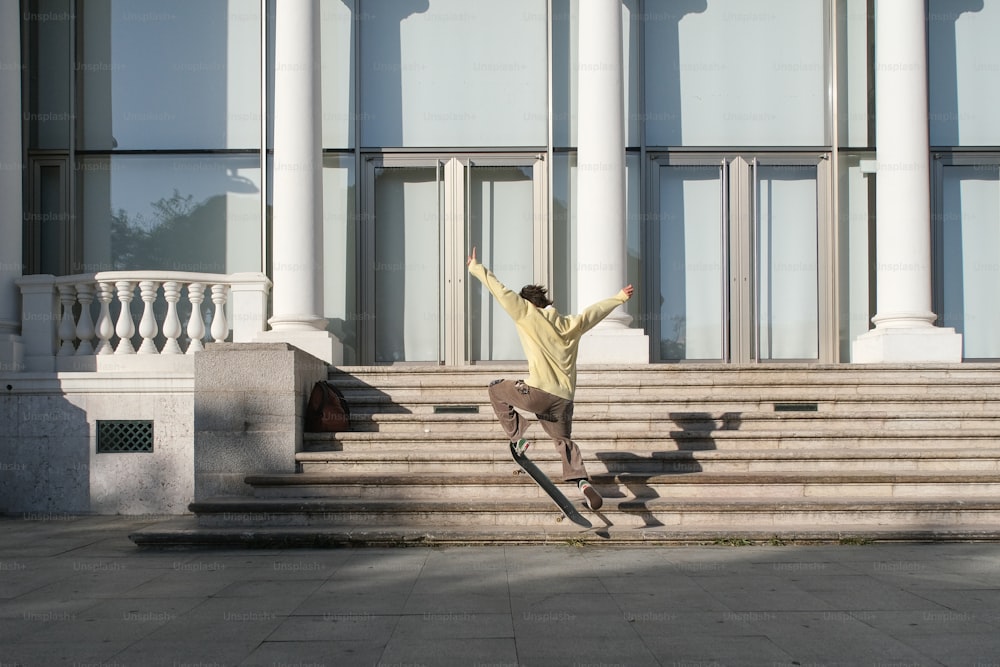 um homem andando de skate na lateral de um conjunto de escadas