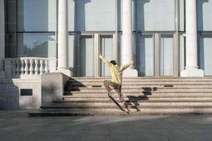 Un hombre montando una patineta por el costado de un conjunto de escaleras