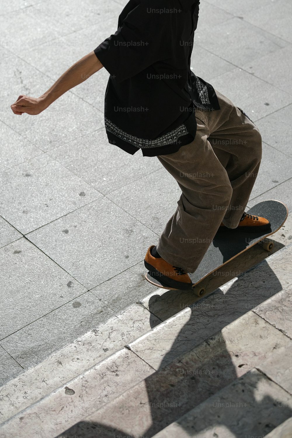ein mann, der auf einem skateboard einen bürgersteig hinunterfährt