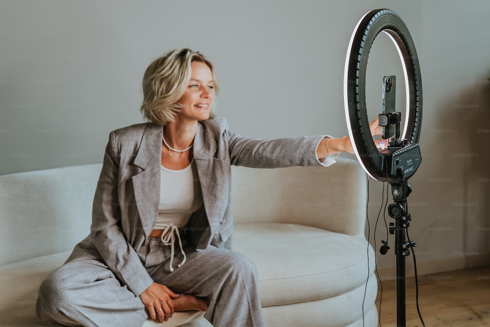 a woman sitting on a couch holding a camera