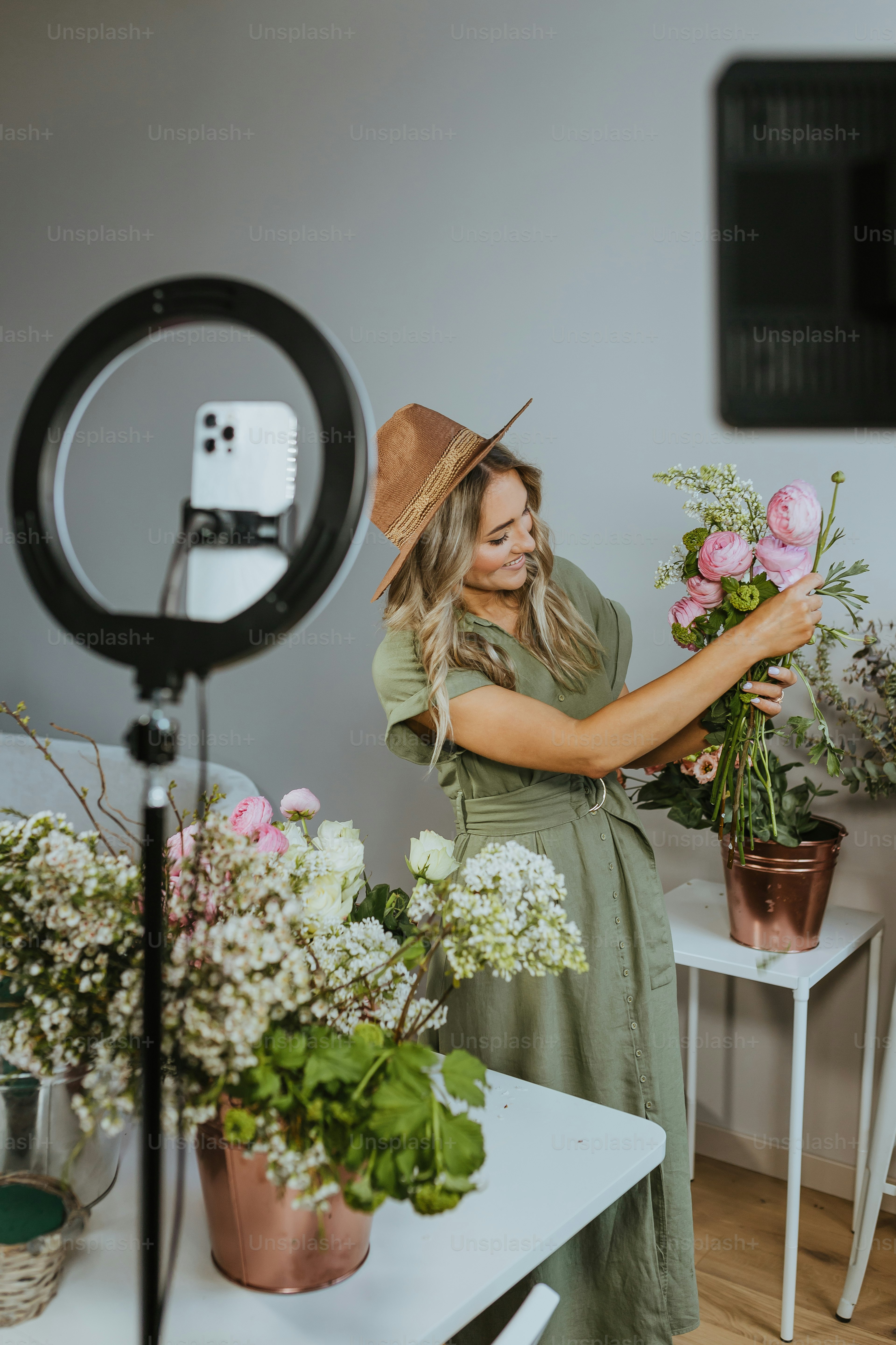 eine frau, die einen blumenstrauß vor einer kamera hält