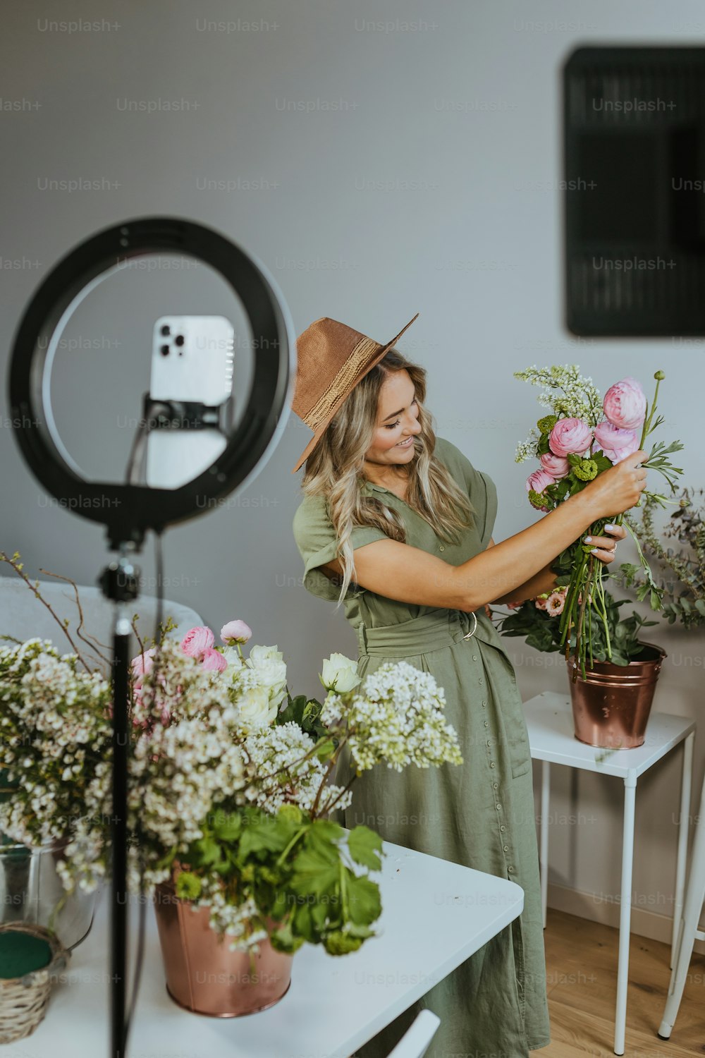 uma mulher segurando um buquê de flores na frente de uma câmera