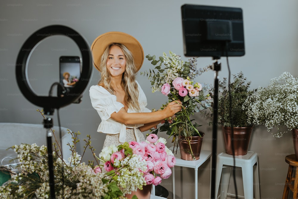 Una mujer sosteniendo un ramo de flores frente a una cámara