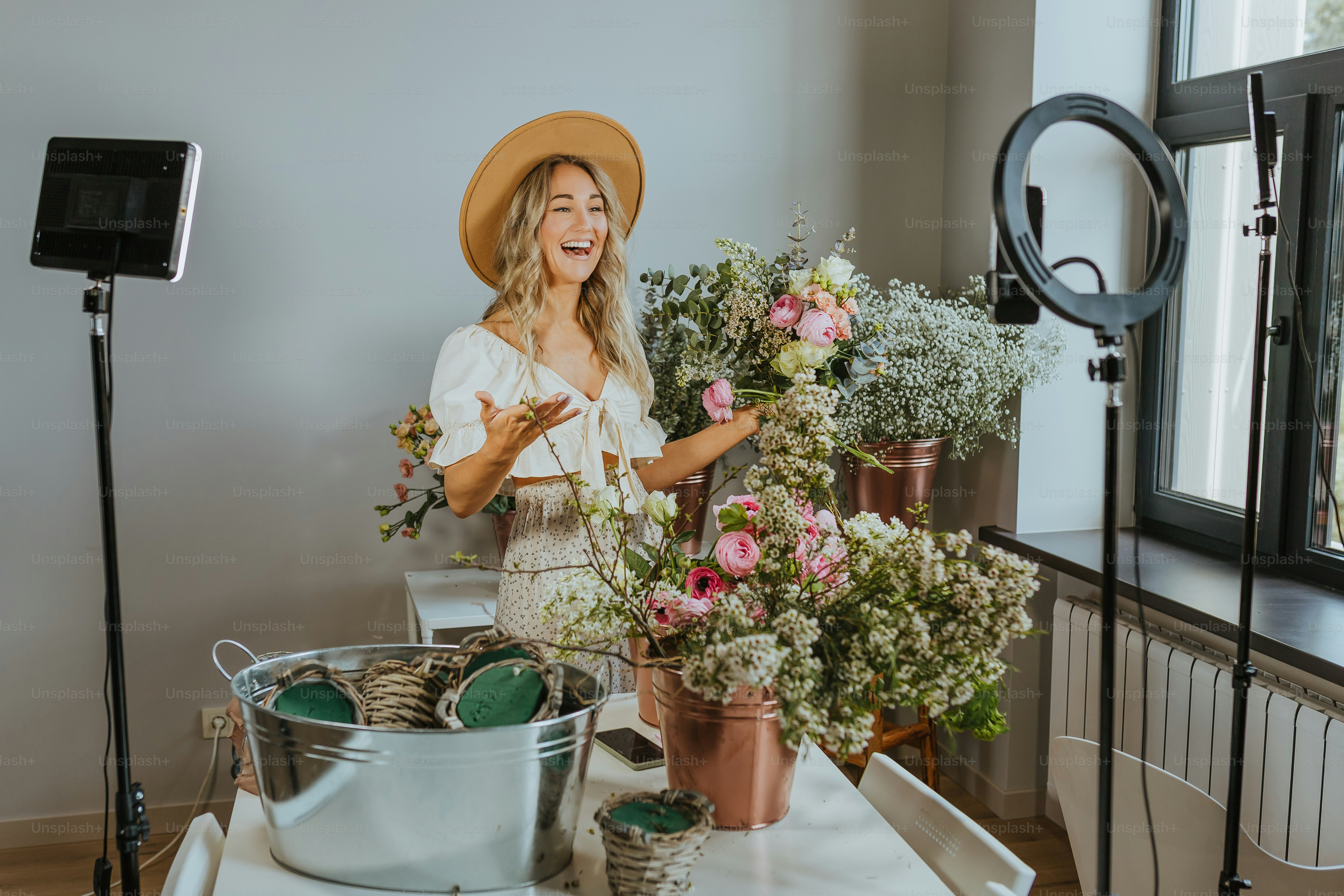 Une femme debout devant une table avec des fleurs