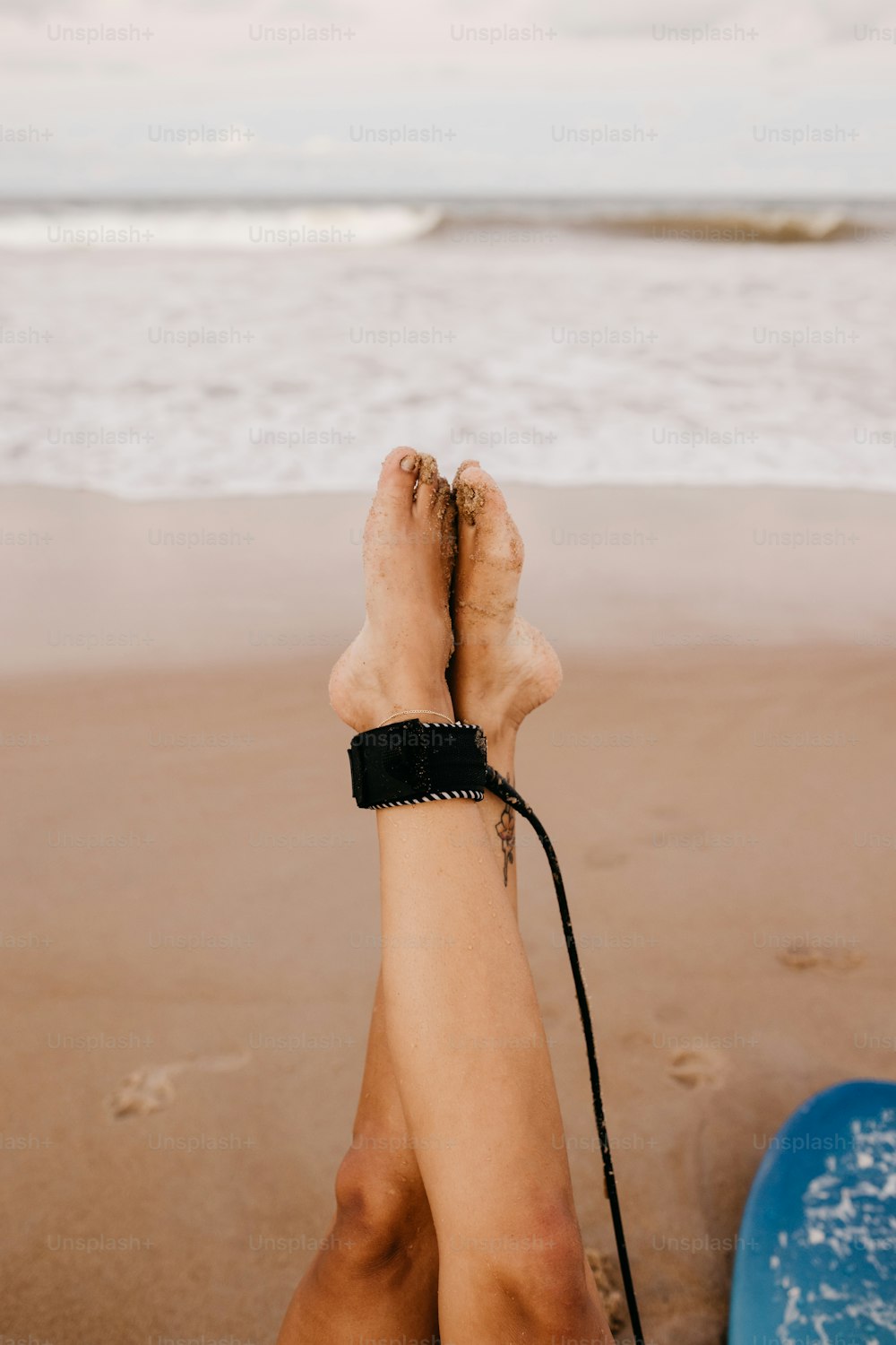 a person with their feet up on the beach