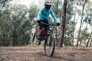 a man riding a bike through a forest filled with trees