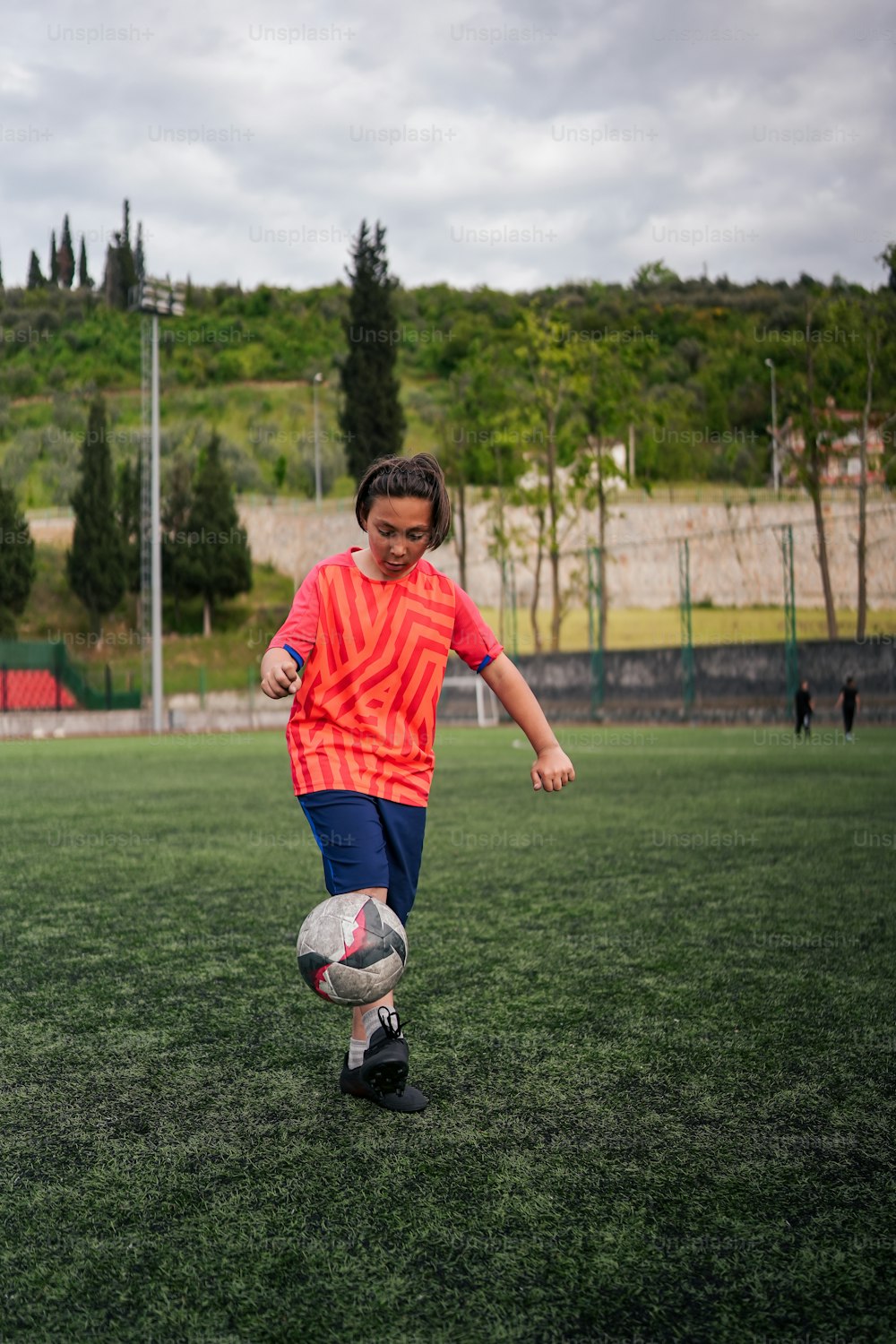 Un giovane ragazzo che calcia un pallone da calcio su un campo