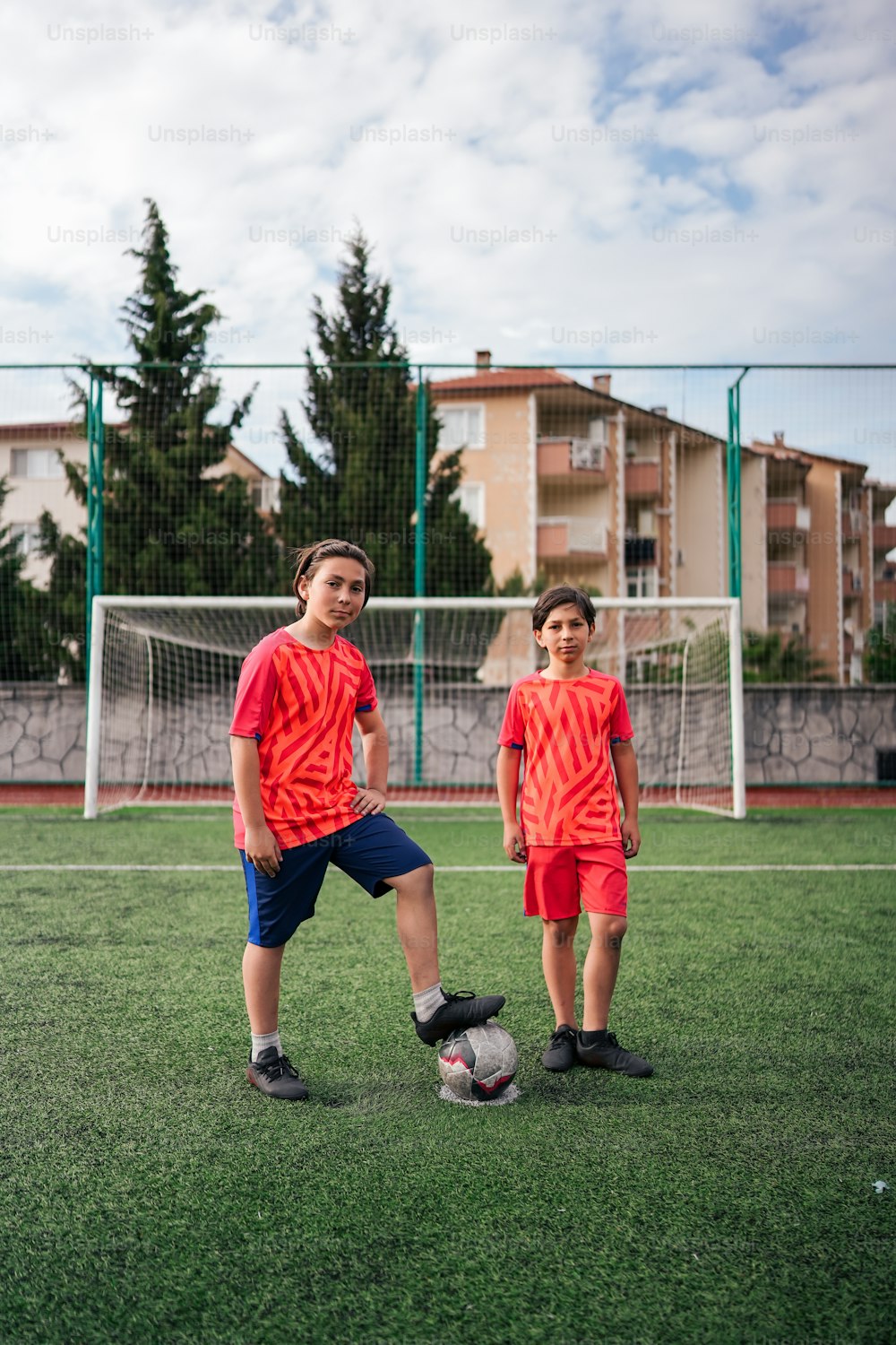 Un par de jóvenes parados encima de un campo de fútbol
