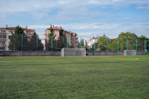 um campo de futebol com um gol de futebol e edifícios ao fundo
