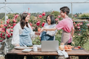 a group of people standing around a table with a laptop