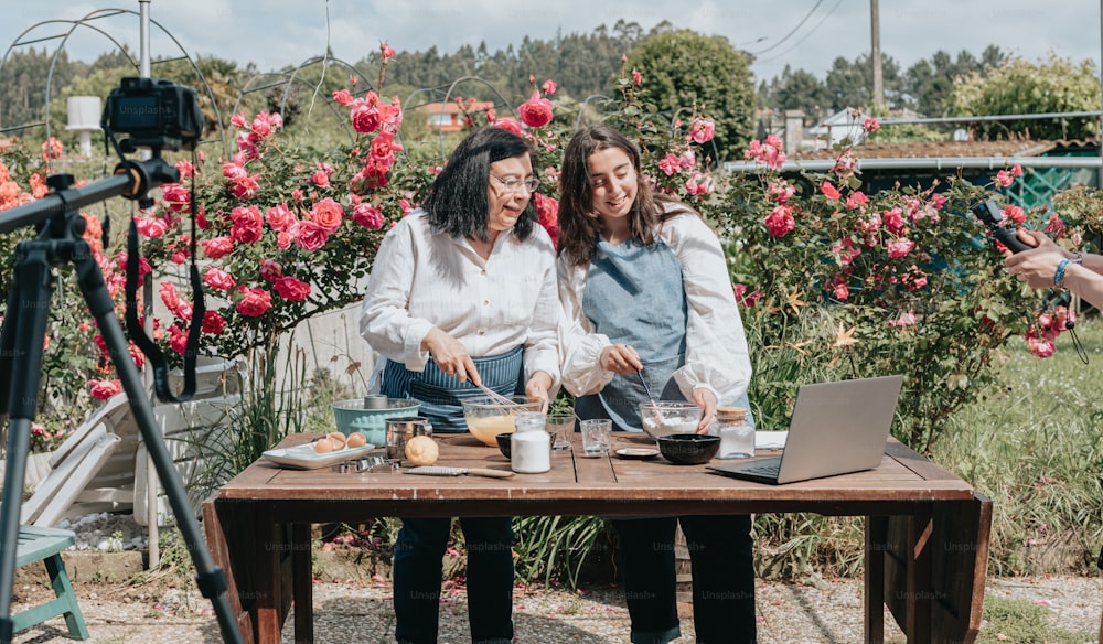 a couple of women sitting at a table with a laptop