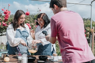 a group of people standing around a table with food