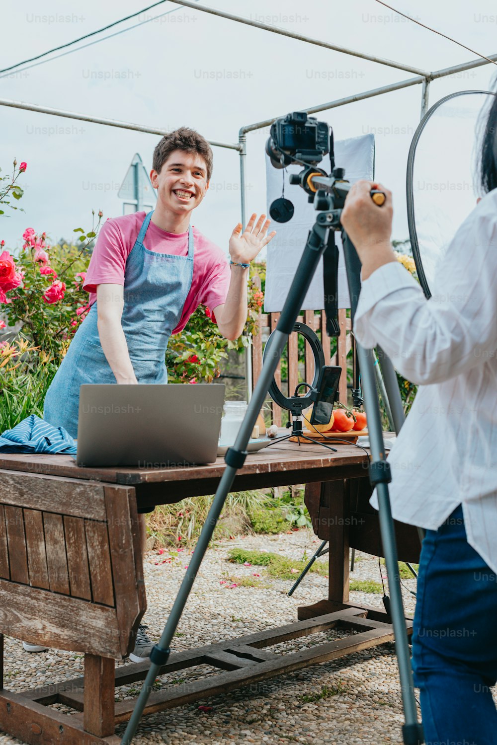 a woman is filming a man on a laptop