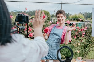uma mulher tirando uma foto de um homem em um jardim