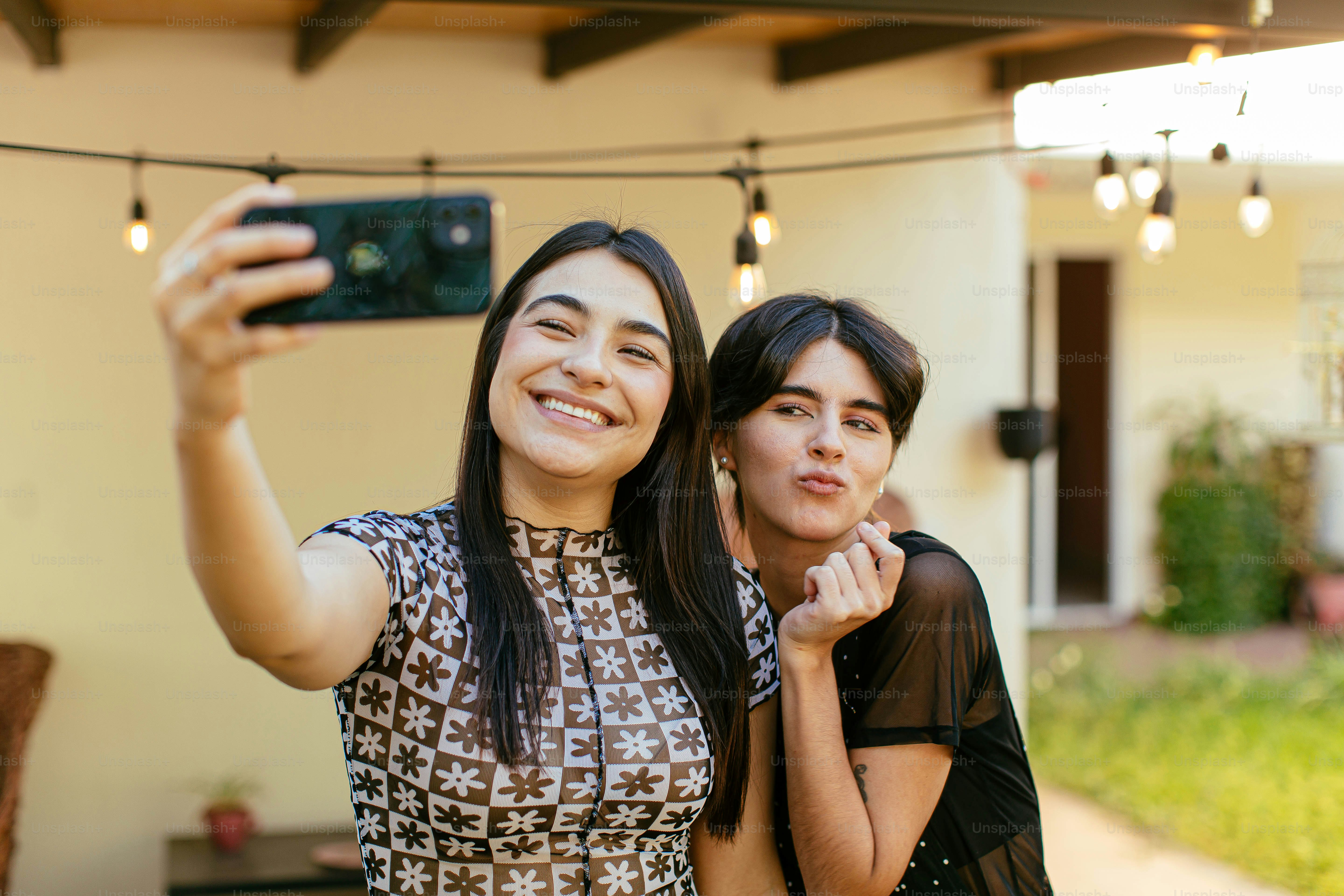 two women taking a picture with a cell phone