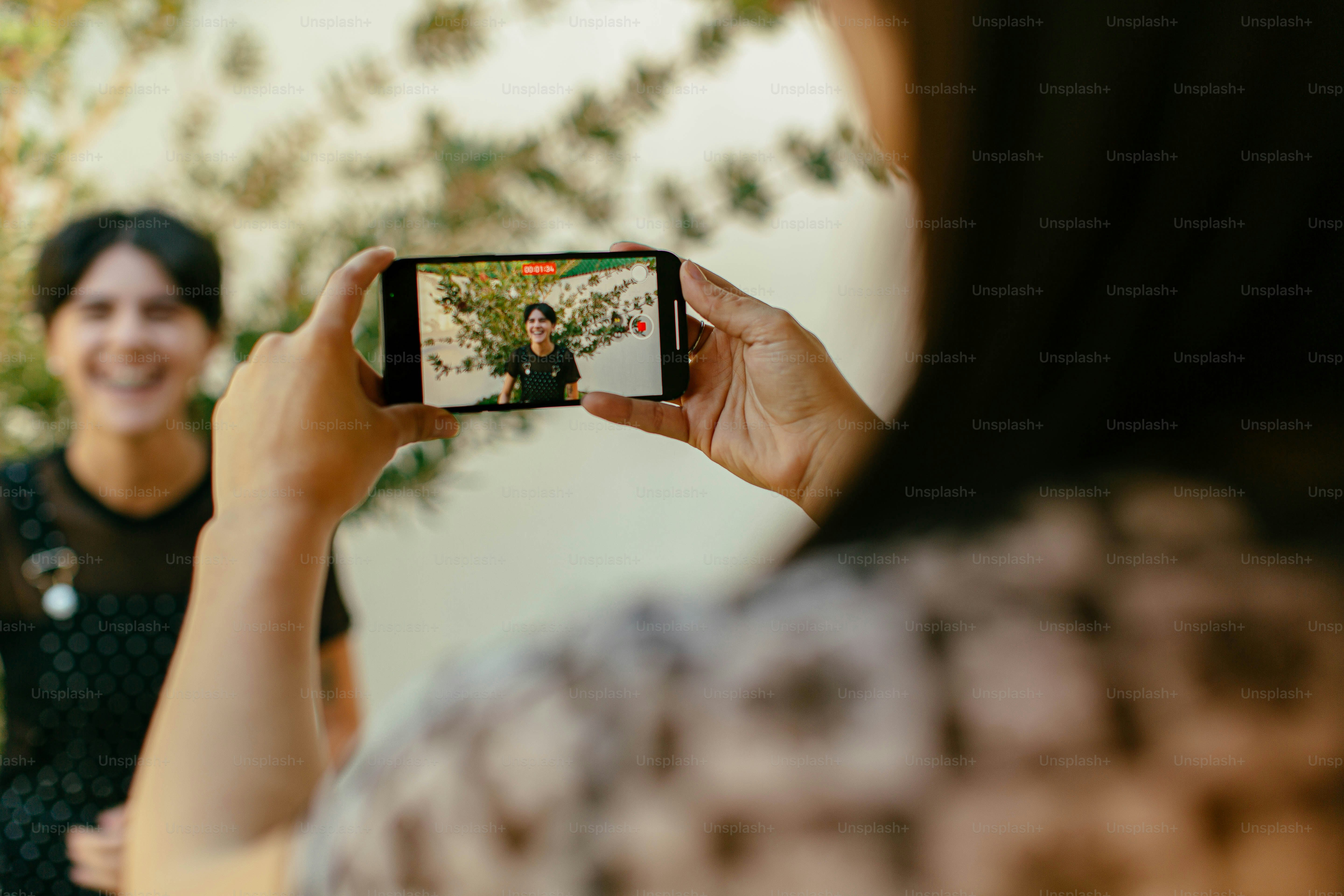 携帯電話で自分の写真を撮る女性