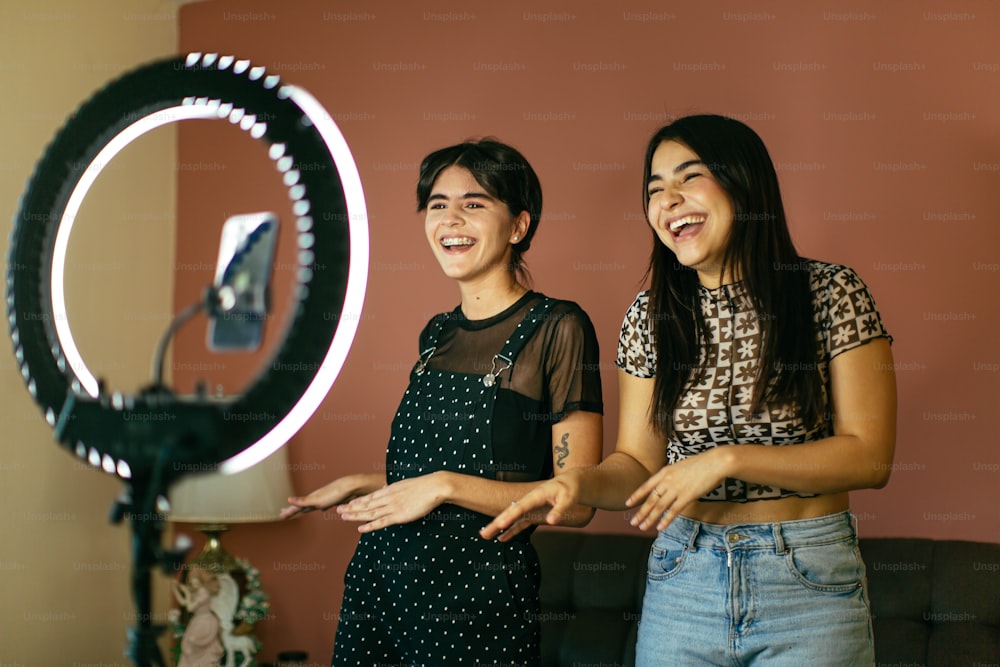 two women standing next to each other in front of a mirror