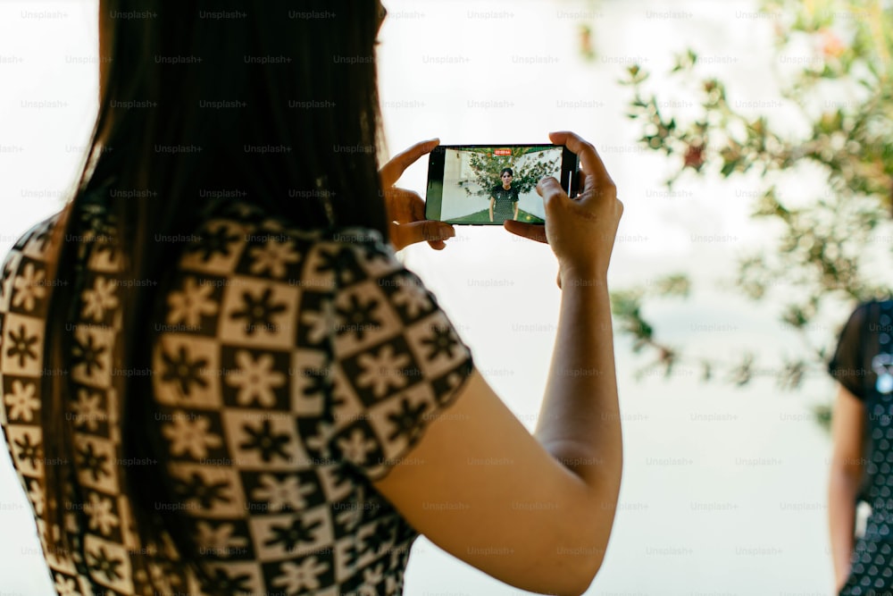 a woman taking a picture of herself with her cell phone