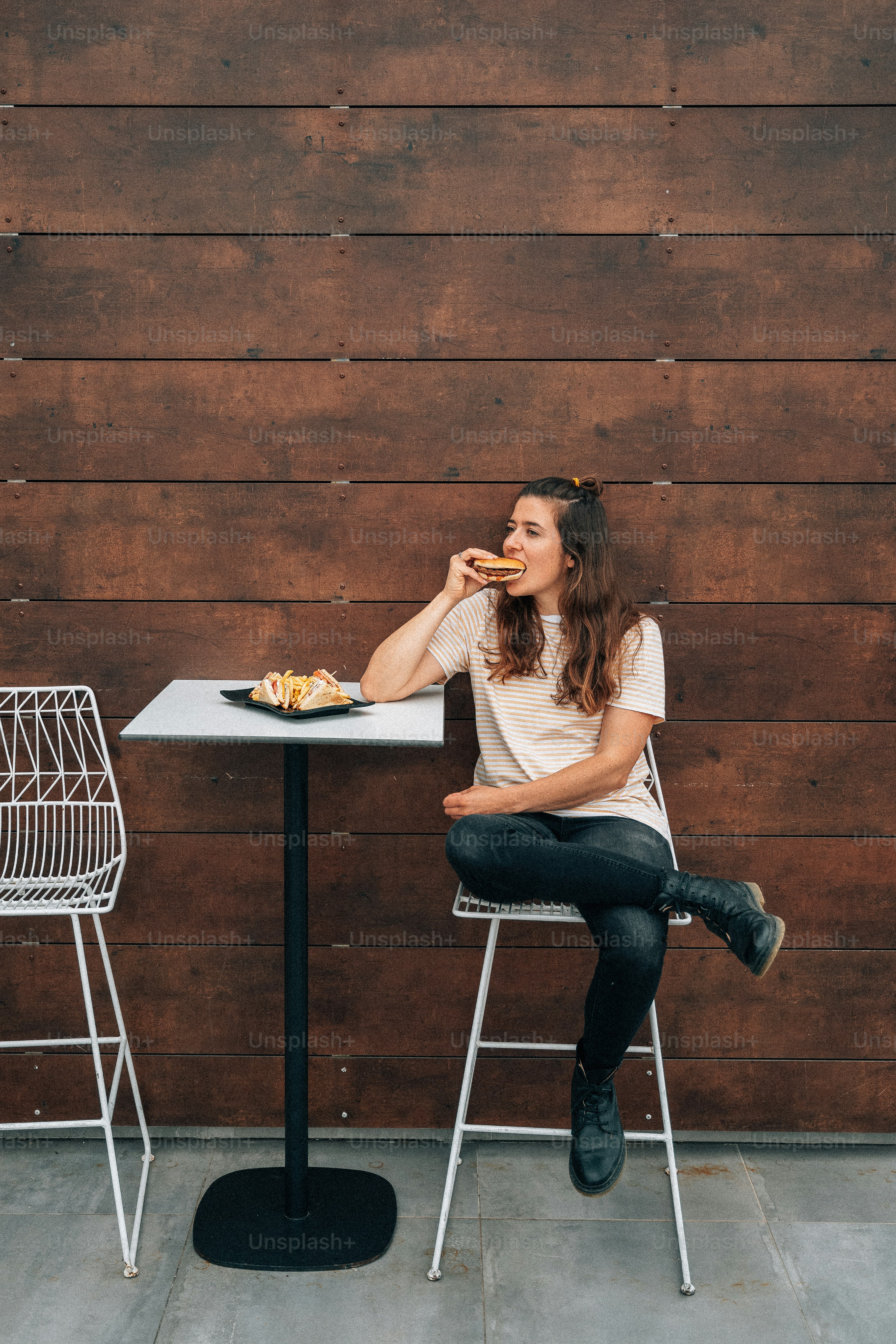 Una mujer sentada en una mesa comiendo alimentos