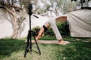 a woman doing a yoga pose in a yard